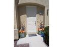 Entrance with decorative flowers flanking a white front door at 6324 Desert Leaf St # 3, North Las Vegas, NV 89081