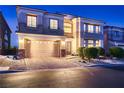 Charming two-story home featuring manicured landscaping and a two-car garage at twilight at 6750 Quapaw St, Las Vegas, NV 89149