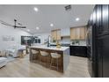 Bright, open kitchen with island seating, modern appliances, contrasting cabinets, and open floorplan at 679 Riverband Pl, Henderson, NV 89052