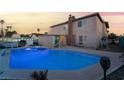 Private backyard featuring a sparkling pool with slide, lush greenery, and a charming patio area at 7018 Berkshire Pl, Las Vegas, NV 89147