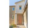 Inviting front entrance featuring a stylish salmon-colored door with a textured exterior and adjacent garden at 7175 Steubling Glen St, North Las Vegas, NV 89084