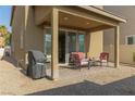 Outdoor patio space with comfortable seating, a barbeque, and desert landscaping in the backyard at 7175 Steubling Glen St, North Las Vegas, NV 89084