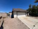 Single story home with a two car garage and a side yard in need of landscaping at 7300 Mountain Moss Dr, Las Vegas, NV 89147