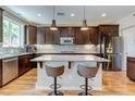 Modern kitchen featuring stainless steel appliances, a mosaic backsplash, and a central island with seating at 8232 Silver Vine St, North Las Vegas, NV 89085