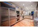 Modern kitchen with stainless steel appliances, custom cabinets, and hardwood floors at 9000 Opus Dr, Las Vegas, NV 89117