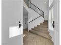 Inviting foyer with tile flooring, staircase with black iron railing leading to the upper level at 9290 S Cool Creek Ave, Las Vegas, NV 89147