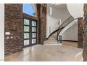 An elegant foyer with a grand staircase and stylish black metal bannister at 9501 Balatta Canyon Ct, Las Vegas, NV 89144