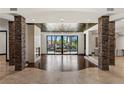 Spacious living room with stone pillars, fireplace and sliding glass doors to the pool and patio area at 9501 Balatta Canyon Ct, Las Vegas, NV 89144