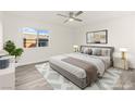Cozy bedroom with a ceiling fan, a neutral color scheme, and a large window at 10525 Shiny Skies Dr, Las Vegas, NV 89129