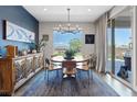 Inviting dining area features a large window with views, elegant chandelier, and sliding glass doors at 10954 Free Flow Pl, Las Vegas, NV 89138