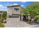 Contemporary two-story home featuring a neutral color scheme, paver driveway and low maintenance landscaping at 10954 Free Flow Pl, Las Vegas, NV 89138