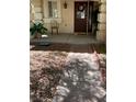Inviting covered porch with decorative plants and a welcoming wreath on the front door creates a warm entrance at 11021 Pentland Downs St, Las Vegas, NV 89141