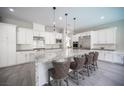 Modern kitchen with white cabinets, granite countertops, stainless steel appliances, and a large island with seating at 12018 Vento Forte Ave, Las Vegas, NV 89138