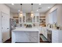 Bright kitchen features stainless appliances, white cabinets, marble countertops, island, and open shelving at 167 Thunder Plains Way, Henderson, NV 89012