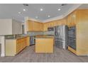 Contemporary kitchen featuring stainless steel appliances, wooden cabinets, and a functional center island at 1717 Double Arch Ct, Las Vegas, NV 89128