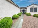 Inviting walkway to the front door framed by lush green bushes at 2557 Terrytown Ave, Henderson, NV 89052