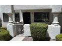 Charming condo entrance featuring a black door, wrought iron gate, and lush landscaping at 2704 Otter Creek Ct # 101, Las Vegas, NV 89117