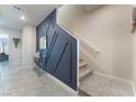 Inviting hallway featuring a decorative wall, tiled floors, and a carpeted staircase at 3815 Corellia Ave, North Las Vegas, NV 89084
