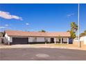 Charming single-story home featuring a tile roof, two-car garage, and well-maintained landscaping on a sunny day at 4454 Harmony Ct, Las Vegas, NV 89121