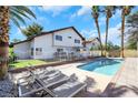 Backyard pool with lounge chairs offers relaxation and entertainment in a private outdoor space surrounded by palm trees at 4680 Freshwater Dr, Las Vegas, NV 89103
