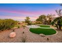 Beautiful backyard with desert landscaping, a green lawn, a fire pit and scenic golf course views at 4718 Atlantico St, Las Vegas, NV 89135
