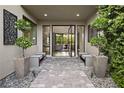 Inviting entryway featuring stone pavers, modern benches, decorative wall art, and a view of the open living space at 5 Moonfire Dr, Las Vegas, NV 89135