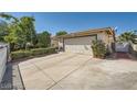 View of the home featuring a wide driveway and attached garage for a classic suburban appeal at 5181 Morris St, Las Vegas, NV 89122