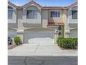 Neutral colored townhome with a two-car garage, tidy landscaping, and a front door at 5221 Tropical Peach Dr, Las Vegas, NV 89118