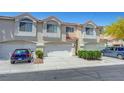 Townhome featuring a two-car garage, neutral stucco exterior, and a terracotta roof at 5221 Tropical Peach Dr, Las Vegas, NV 89118