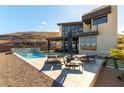 Backyard pool area with lounge chairs, covered patio, and mountain views at 5436 Succulent Rose Dr, Las Vegas, NV 89135
