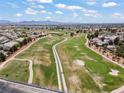 Scenic aerial view of a community featuring expansive green spaces, a golf course, and mountain backdrop at 5655 E Sahara Ave # 2044, Las Vegas, NV 89142