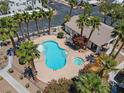 Aerial view of a sparkling community pool and spa area surrounded by lush landscaping and palm trees at 5655 E Sahara Ave # 2044, Las Vegas, NV 89142