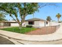 A quaint single-story home with manicured lawn and fence at 5921 Halifax Ave, Las Vegas, NV 89107