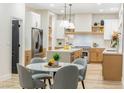 Modern kitchen with stainless steel appliances, white cabinets, center island, and eat in dining area at 62 Incline Village Ct, Henderson, NV 89074