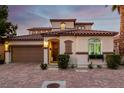 Inviting two-story home features a Spanish-style roof, lush landscaping, and an attached two-car garage at 63 Via Di Mello, Henderson, NV 89011