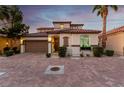 Beautiful two-story home featuring a Spanish tile roof, lush landscaping, and a spacious two-car garage at 63 Via Di Mello, Henderson, NV 89011