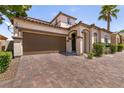 Two car garage of a charming house with brick paved driveway in front at 63 Via Di Mello, Henderson, NV 89011