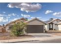 Lovely single story home showcasing a two car garage and desert landscaping in front at 6438 Rose Tree Ln, Las Vegas, NV 89156