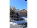 Charming single-story home with a two-car garage and desert landscaping in the front yard at 7497 Alamo Ranch Ave, Las Vegas, NV 89179