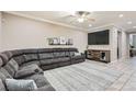 Spacious living room featuring a large sectional sofa, tile floors, and neutral decor with large tv at 7497 Alamo Ranch Ave, Las Vegas, NV 89179