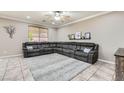 Comfortable living room with a large gray sectional, neutral walls, and a ceiling fan at 7497 Alamo Ranch Ave, Las Vegas, NV 89179