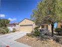 Charming single-story home boasts a neutral color palette, well-manicured landscaping, and a spacious two-car garage at 7624 Fruit Dove St, North Las Vegas, NV 89084