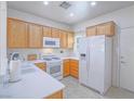 Well-lit kitchen boasts white appliances, oak cabinets, and ample counter space for meal preparation at 7624 Fruit Dove St, North Las Vegas, NV 89084