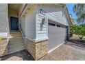 Attached two-car garage with brick-paved driveway, stone accents, and a convenient entryway to the home at 96 Campbelltown Ave, Henderson, NV 89015