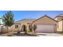 Inviting single-story home featuring a two-car garage, desert landscaping, and a welcoming entrance at 1027 Dawn Valley Dr, North Las Vegas, NV 89031