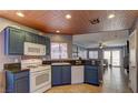 Well-equipped kitchen features blue cabinetry, a gas range, and views into the adjacent living space at 10456 Processor Ct, Las Vegas, NV 89129
