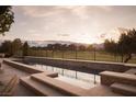 Luxury infinity pool overlooks a golf course with mountain views at 1413 Iron Hills Ln, Las Vegas, NV 89134