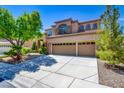 Stunning two-story home with a three-car garage and meticulously landscaped front yard at 1701 Tesara Vista Pl, Las Vegas, NV 89128