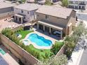 Aerial view of a backyard with a pool, spa, covered patio, and lush landscaping at 176 Jay Porter Ave, Henderson, NV 89002