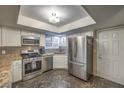 Updated kitchen featuring stainless steel appliances, granite countertops, and stylish marbled flooring at 2231 Marlboro Dr, Henderson, NV 89014